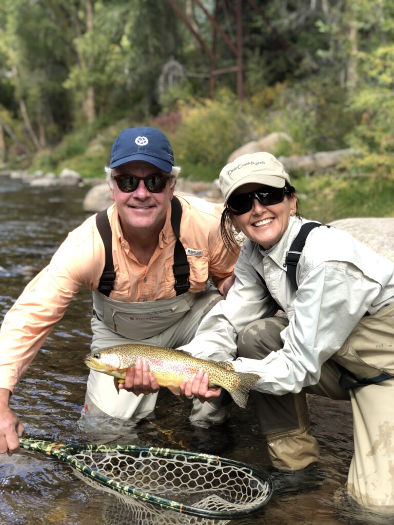 Couple holding a brown trout while fishing with Colorado fly fishing guides