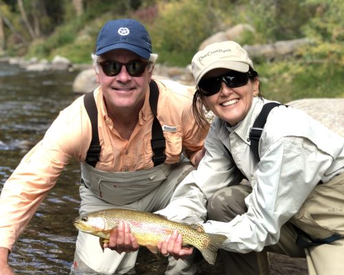 Couple holding a brown trout while fishing with Colorado fly fishing guides