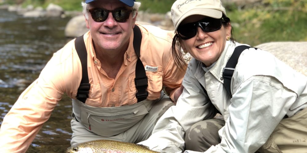 Couple holding a brown trout while fishing with Colorado fly fishing guides